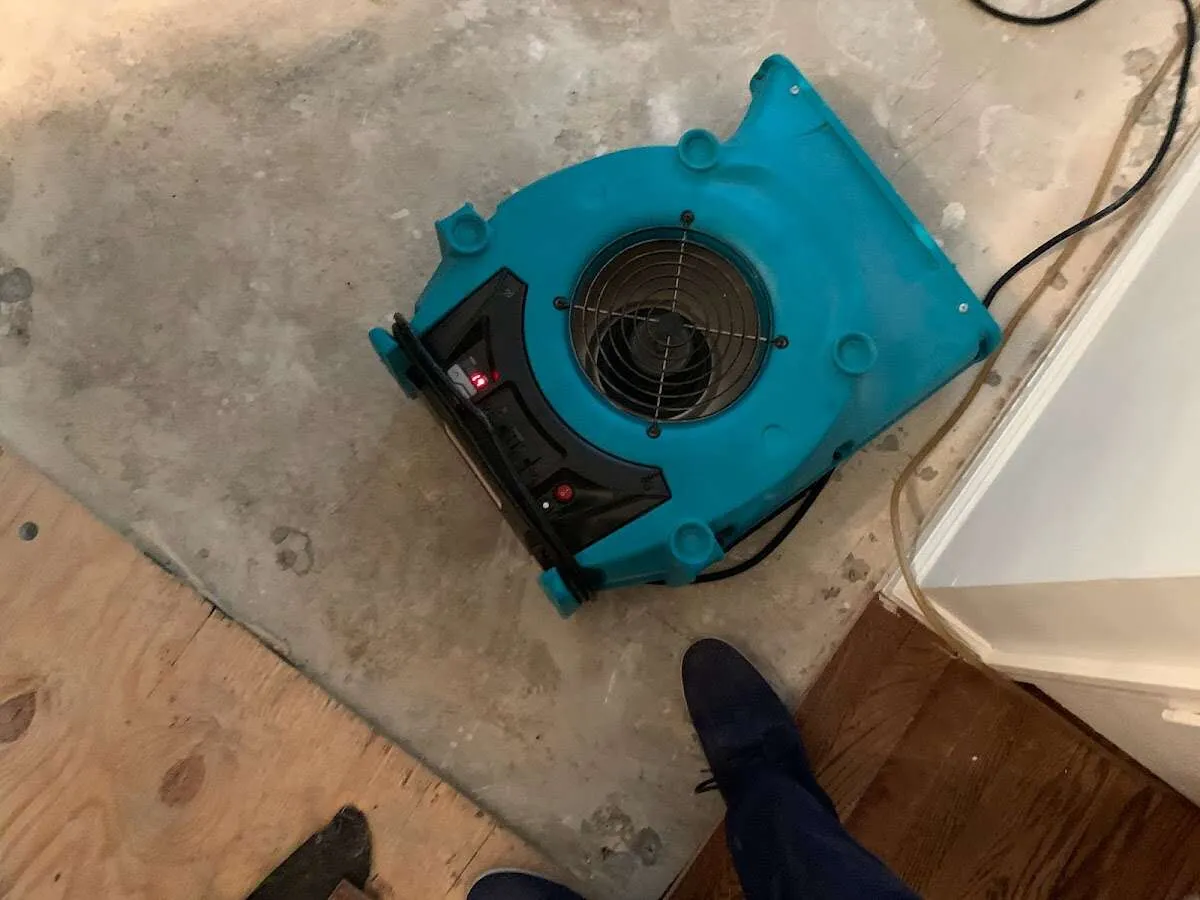 Air mover drying subfloor during Commercial Water Damage Restoration in Baker